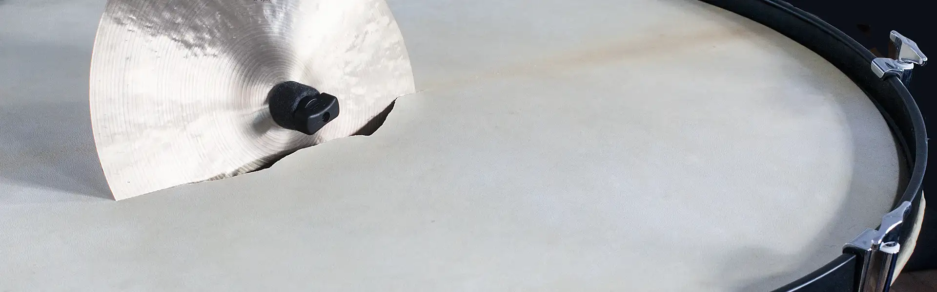 Ein aufgehängtes Becken steckt in einem gerissenen Trommelfell