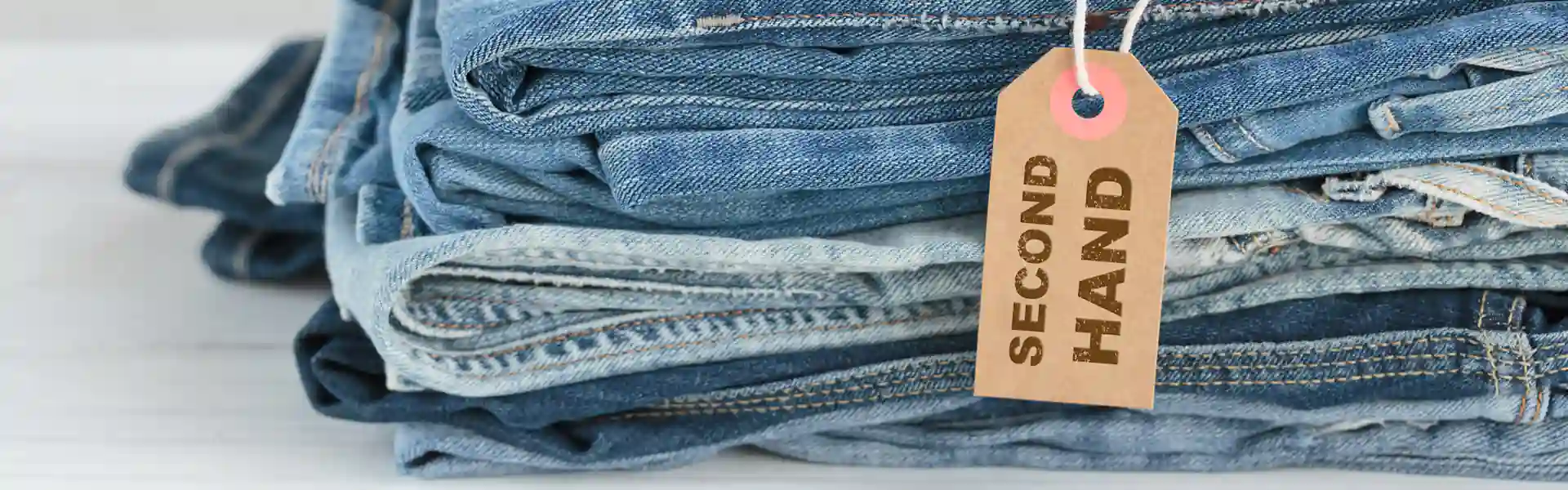 Gebrauchte Jeans mit einem Schild „Second Hand“